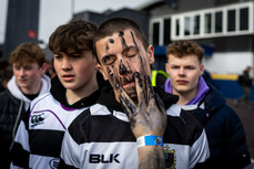 James Murphy paints the faces of fellow school mates as they arrive for the game 12/3/2024