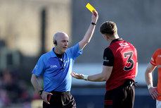 Liam Devenney shows a yellow card to Ryan McEvoy 27/4/2024