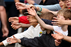 A view of young fans holding their hands out for gloves and balls after players finish their round 10/9/2023