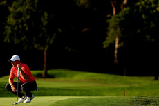 Rory McIlroy crouches on the 18th green 8/9/2023