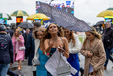 Racegoers shield themselves from the rain and wind at the Fairyhouse Easter Festival 10/4/2023
