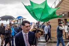 Racegoers shield themselves from the rain and wind at the Fairyhouse Easter Festival 10/4/2023
