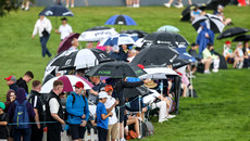 Spectators take shelter from the rain after play is halted 10/9/2023