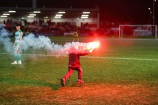 A young kids grabs one of the flare that was thrown at the Shamrock Rovers’ fans from outside the ground 19/4/2024