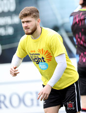 Scott High warms up ahead of the game in a Darkness Into Light branded t-shirt 6/5/2024