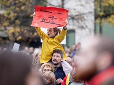 A young spectator holds a sign on her fathers shoulders 27/10/2024 