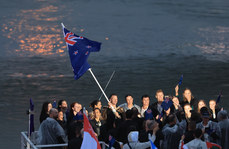 Flag bearers Aaron Gate and Jo Aleh are seen as team New Zealand travels on the Seine River 26/7/2024