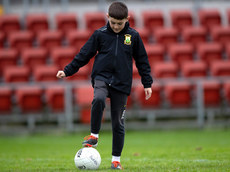 A young Burren supporter plays on the pitch ahead of the game 13/10/2024